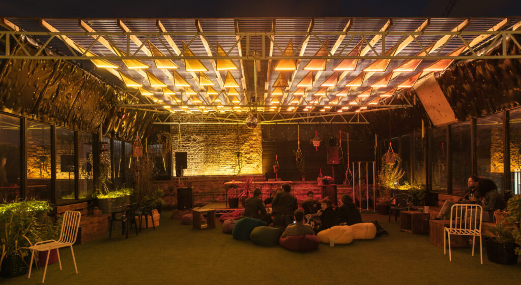 Bespoke lighting design bu Michael Grubb Studio transforms Dalston Roofpark into a dynamic event space, using warm-toned filters, integrated LEDs, and sustainable solutions to enhance the atmosphere after dark.